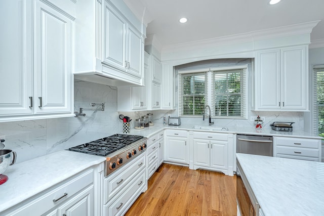 kitchen with light countertops, appliances with stainless steel finishes, a sink, and white cabinets