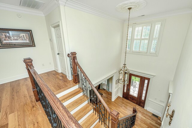 bedroom with multiple windows, ornamental molding, light hardwood / wood-style flooring, and ceiling fan