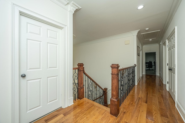 hall featuring recessed lighting, wood finished floors, an upstairs landing, baseboards, and crown molding