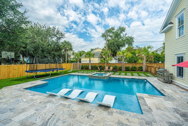 view of swimming pool with a fenced backyard, a trampoline, a yard, a patio area, and a pool with connected hot tub