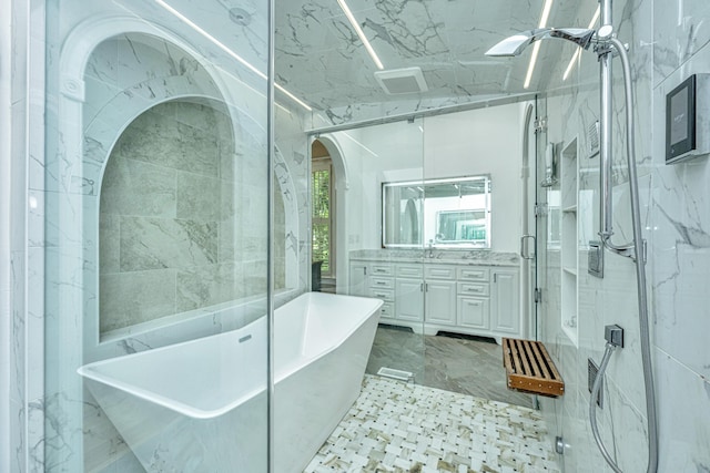 bathroom featuring a freestanding bath, a stall shower, vanity, and tile walls