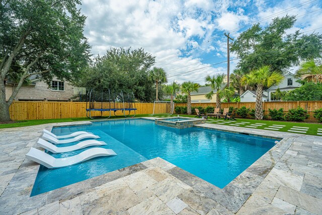 view of pool with a trampoline, an in ground hot tub, a patio, and grilling area