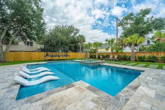 view of swimming pool featuring a trampoline, a patio area, a fenced backyard, and a pool with connected hot tub