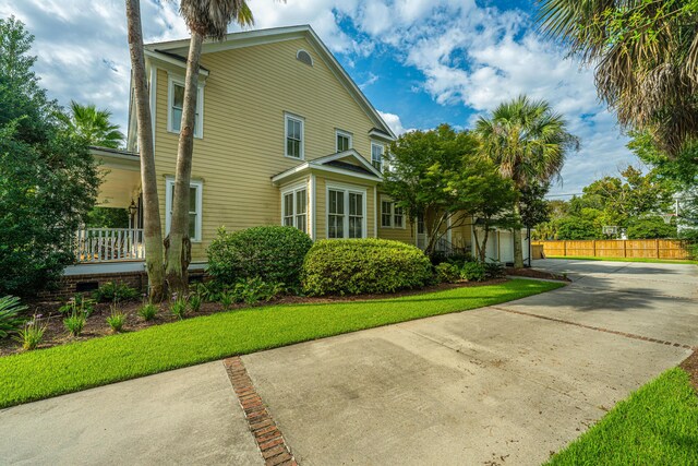 rear view of property with a patio, a sunroom, a swimming pool with hot tub, and a lawn