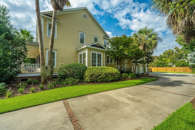 view of side of home featuring a garage, a yard, and fence