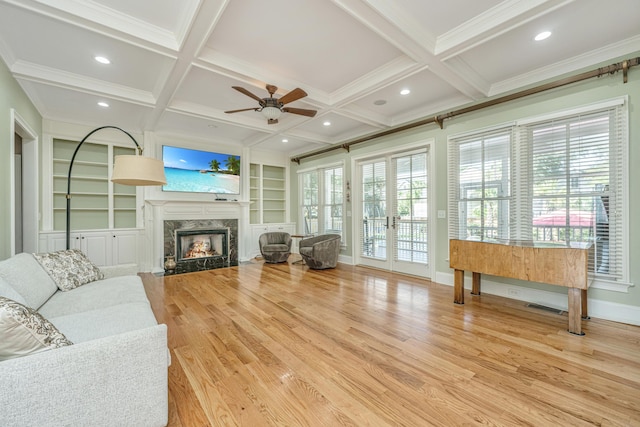 living room with visible vents, coffered ceiling, light wood-type flooring, beam ceiling, and a high end fireplace