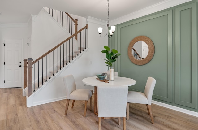 dining area featuring light wood-type flooring, stairs, ornamental molding, and a notable chandelier