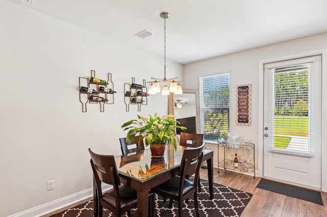 dining space with a notable chandelier and hardwood / wood-style flooring