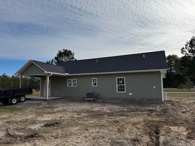 back of house featuring a shingled roof and central AC unit