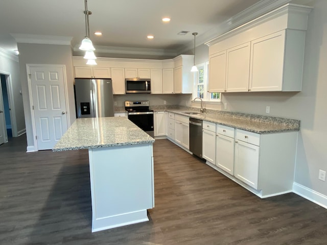 kitchen featuring a center island, crown molding, appliances with stainless steel finishes, white cabinetry, and a sink