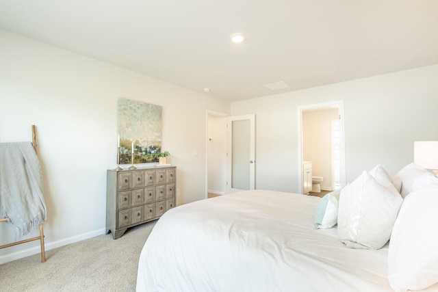 carpeted bedroom featuring ensuite bath