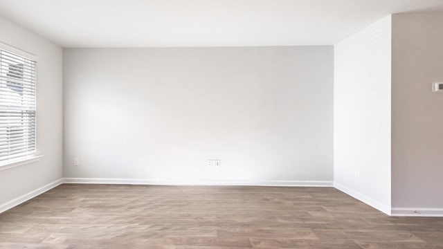 spare room with a healthy amount of sunlight and hardwood / wood-style flooring