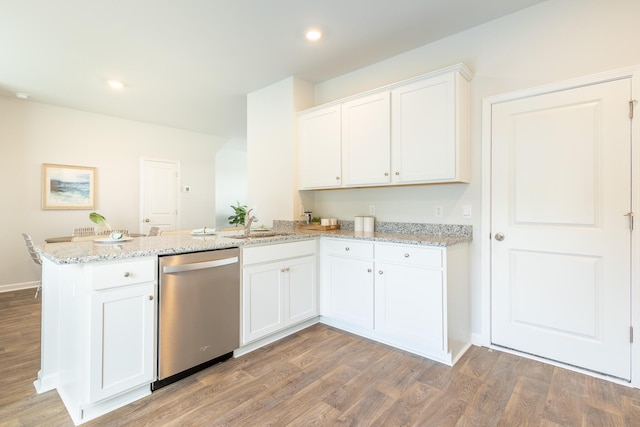 kitchen with dishwasher, light stone counters, and white cabinetry