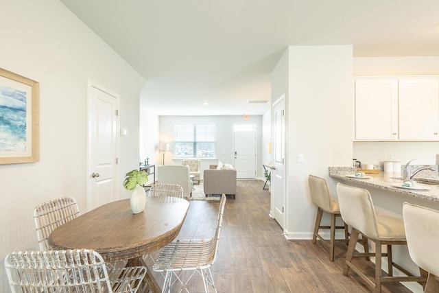 dining space featuring dark hardwood / wood-style floors and sink