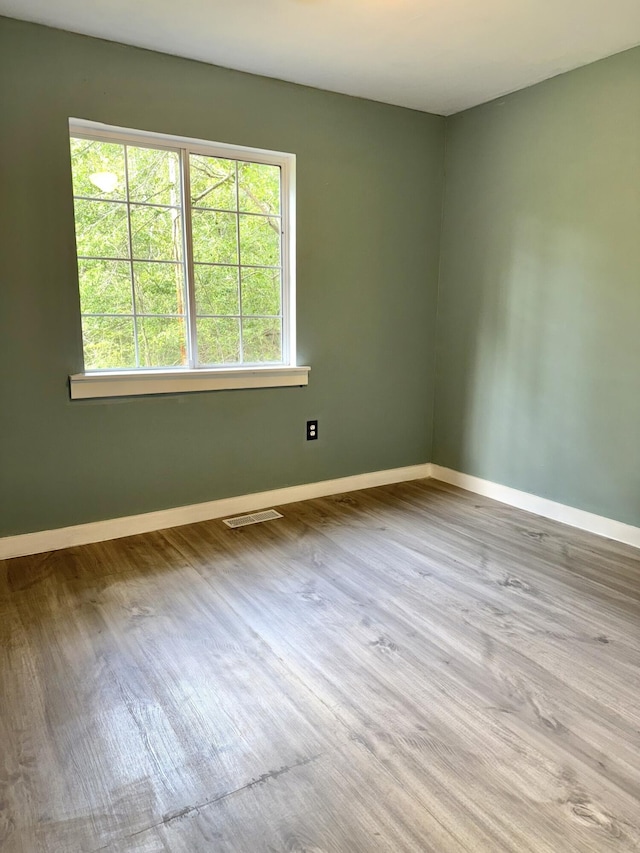 empty room featuring baseboards and wood finished floors