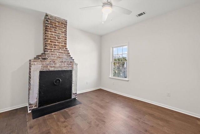 unfurnished living room featuring ceiling fan and dark wood-type flooring