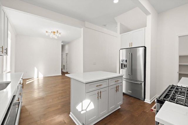 kitchen with white cabinets, high end refrigerator, a kitchen island, and dark hardwood / wood-style floors