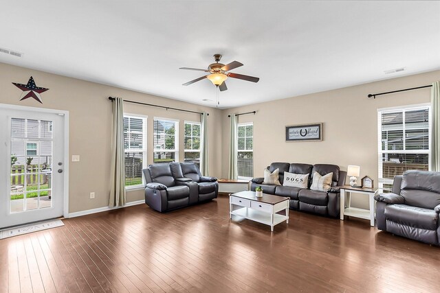 living room with dark hardwood / wood-style flooring, a wealth of natural light, and ceiling fan