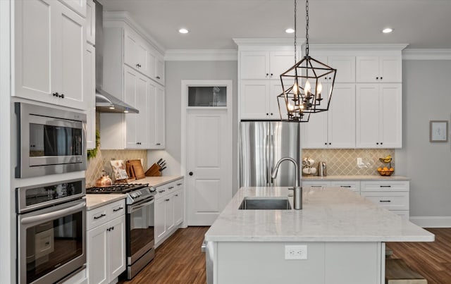 kitchen featuring white cabinets, sink, an island with sink, and appliances with stainless steel finishes