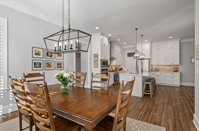 dining room featuring crown molding, dark wood-type flooring, and sink