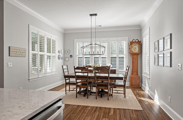 dining space featuring dark hardwood / wood-style flooring, ornamental molding, and an inviting chandelier