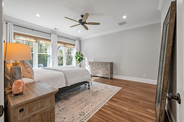 bedroom featuring ceiling fan, dark hardwood / wood-style floors, and ornamental molding