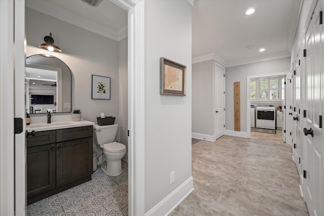 bathroom with vanity, toilet, ornamental molding, and washer / dryer