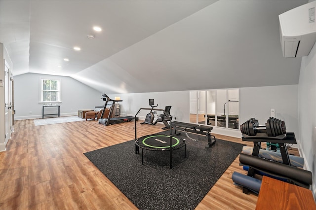 exercise room featuring hardwood / wood-style floors and vaulted ceiling