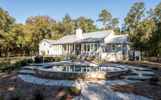 rear view of property featuring a fenced in pool, a patio area, and a sunroom