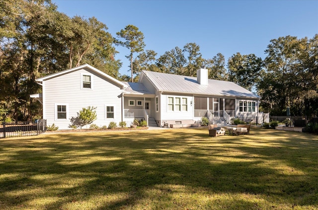 rear view of house with a yard and a sunroom