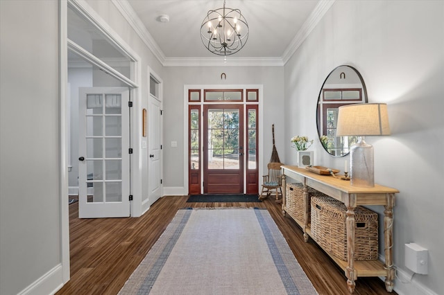 entrance foyer with dark wood-type flooring, ornamental molding, and an inviting chandelier