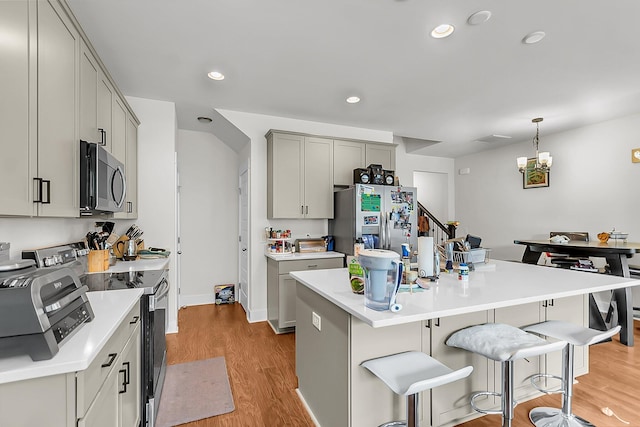 7812 Park Gate Dr, North Charleston, SC 29418 - kitchen featuring appliances with stainless steel finishes, light wood-type flooring, a kitchen bar, light countertops, and recessed lighting