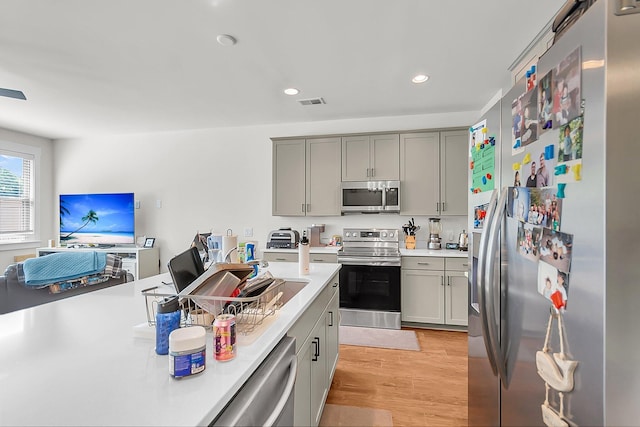 7812 Park Gate Dr, North Charleston, SC 29418 - kitchen with appliances with stainless steel finishes, gray cabinetry, light countertops, light wood-style flooring, and recessed lighting