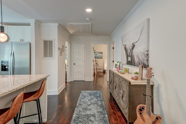 hall featuring attic access, dark wood finished floors, ornamental molding, baseboards, and recessed lighting