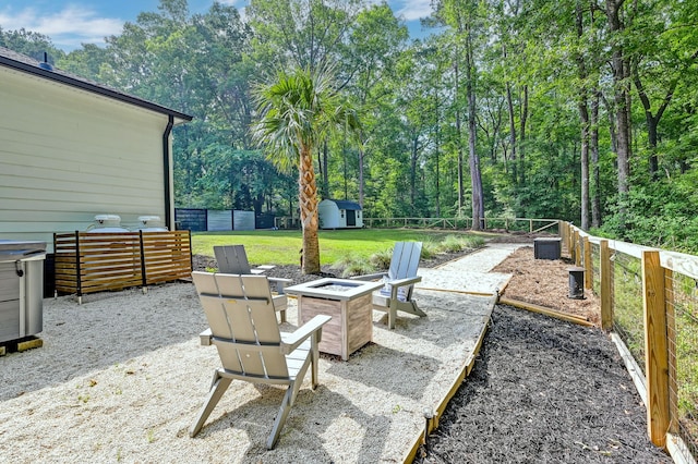 view of patio featuring a storage unit, a fire pit, and an outdoor structure