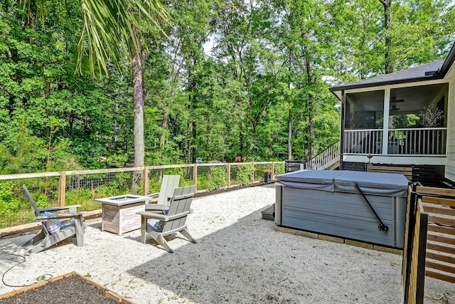 view of patio with a hot tub, a fire pit, and a sunroom