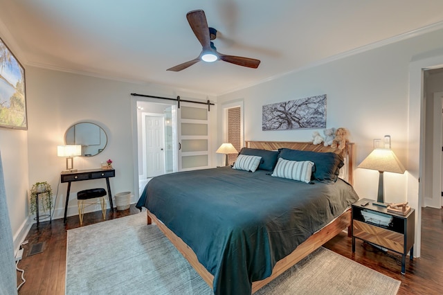 bedroom featuring a barn door, crown molding, wood finished floors, ceiling fan, and baseboards
