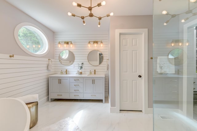 bathroom featuring double vanity, marble finish floors, wooden walls, a freestanding bath, and a shower