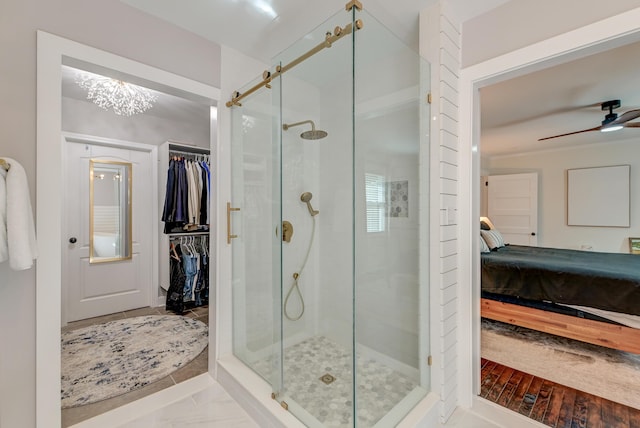 bathroom featuring ensuite bathroom, a stall shower, a spacious closet, and ceiling fan