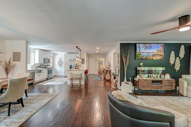 living room featuring crown molding, hardwood / wood-style flooring, recessed lighting, and a ceiling fan