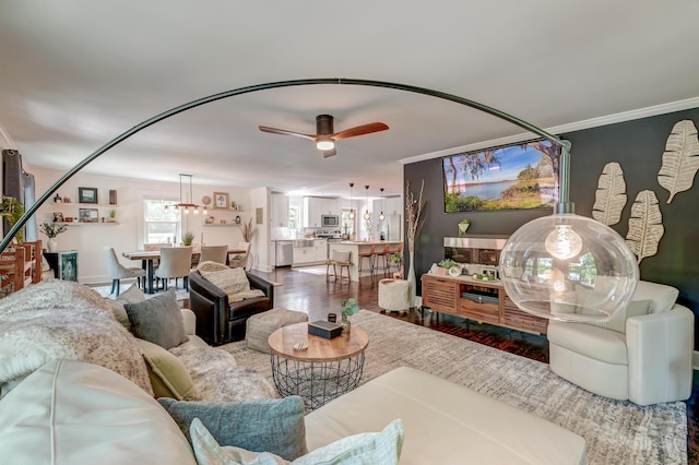 living area featuring a ceiling fan, wood finished floors, and ornamental molding