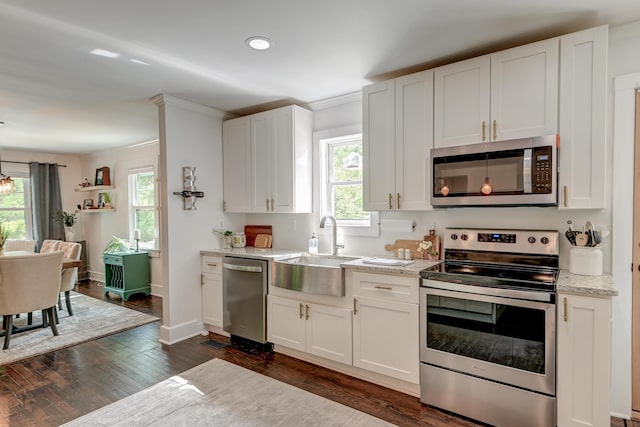 kitchen with appliances with stainless steel finishes, a sink, plenty of natural light, white cabinets, and recessed lighting