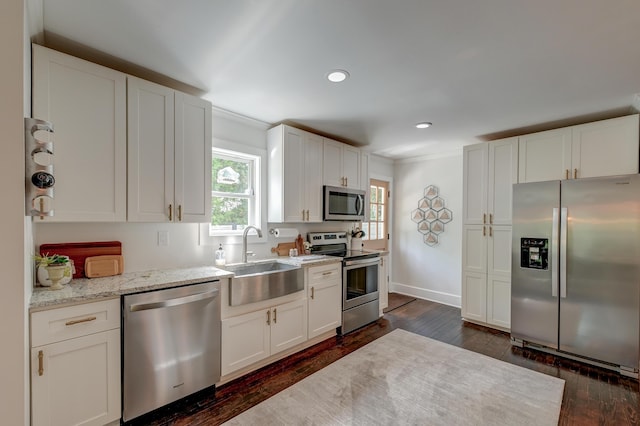 kitchen featuring stainless steel appliances, a sink, dark wood finished floors, white cabinets, and recessed lighting