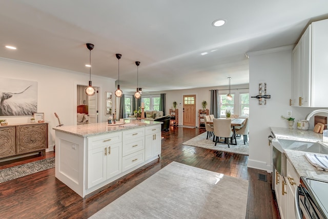 kitchen featuring dark wood-style flooring, white cabinetry, light stone counters, recessed lighting, and a kitchen island