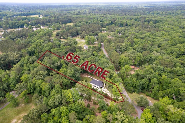 aerial view of property's location with a heavily wooded area and property parcel outlined