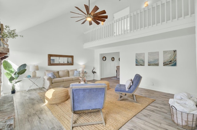 living room featuring hardwood / wood-style flooring, ceiling fan, and high vaulted ceiling