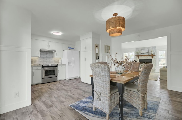 dining area featuring a fireplace and light hardwood / wood-style floors