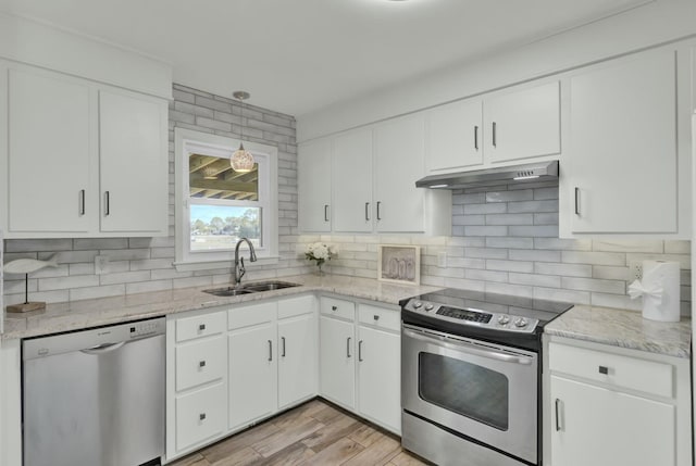 kitchen with white cabinetry, sink, stainless steel appliances, tasteful backsplash, and light hardwood / wood-style flooring