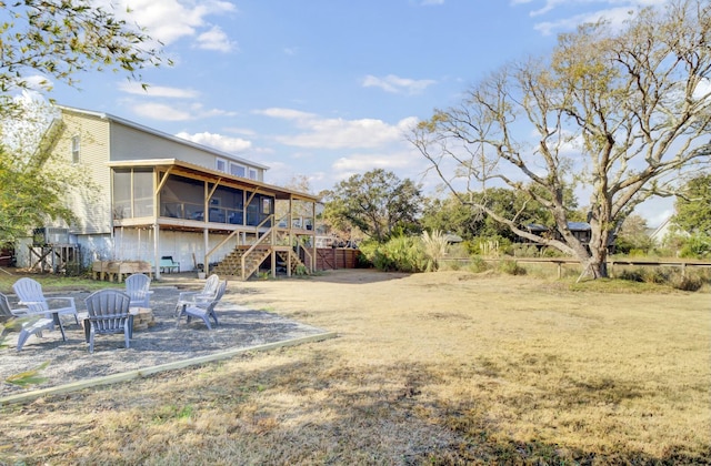 view of yard with an outdoor fire pit and a sunroom