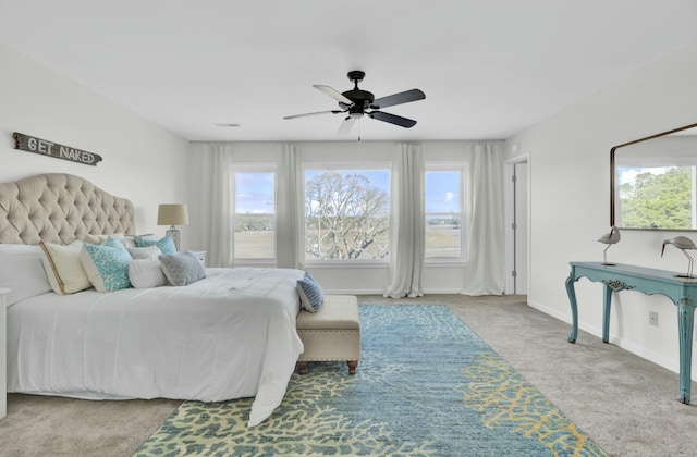 bedroom with light colored carpet, multiple windows, and ceiling fan